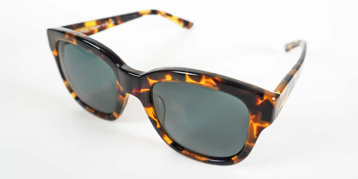 Sunglasses with tortoiseshell frame and dark lenses on a white background