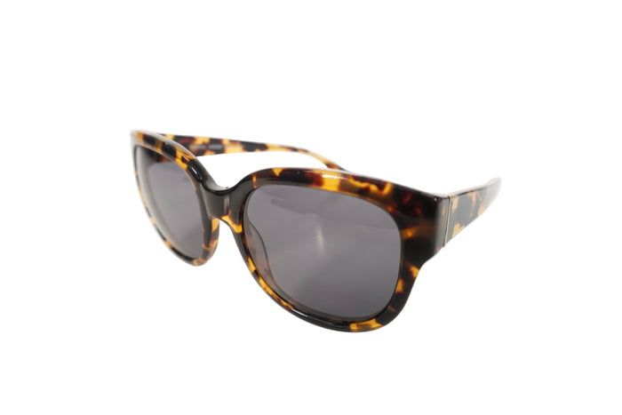 Sunglasses with tortoiseshell frame and dark lenses on a white background