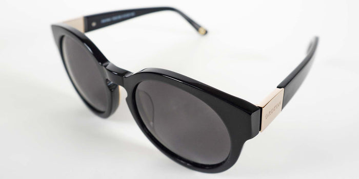 Black sunglasses with gold accents on a white background